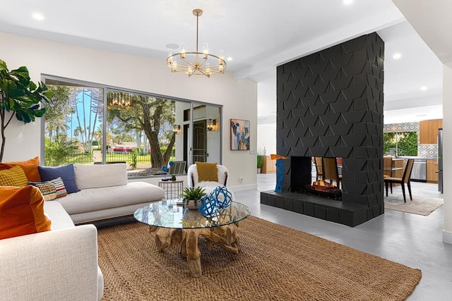 living room with a tiled fireplace, a chandelier, and concrete flooring