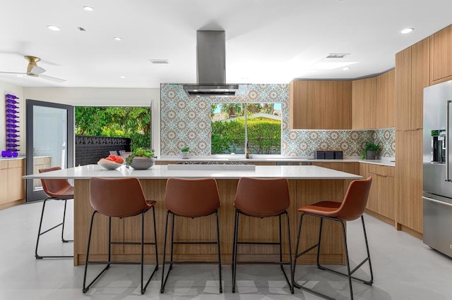 kitchen featuring tasteful backsplash, a spacious island, a breakfast bar, and stainless steel appliances