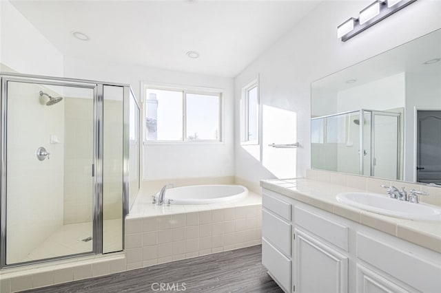 bathroom featuring plus walk in shower, vanity, and hardwood / wood-style flooring