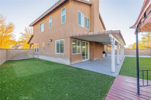 back of property with a yard and a patio area