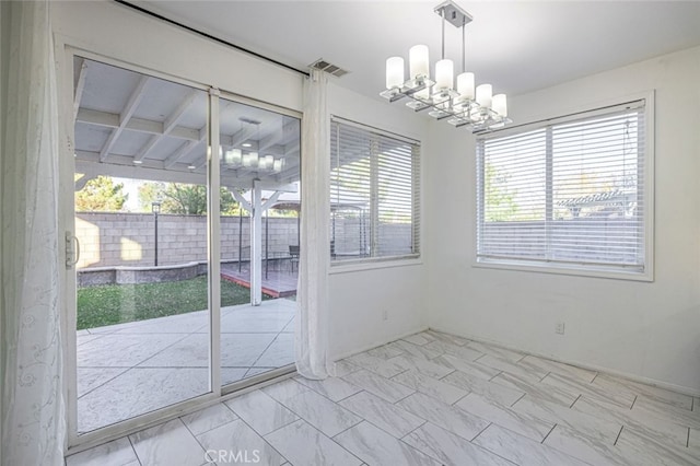 unfurnished dining area featuring an inviting chandelier