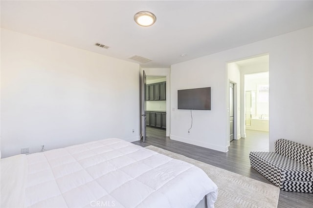 bedroom featuring connected bathroom and wood-type flooring