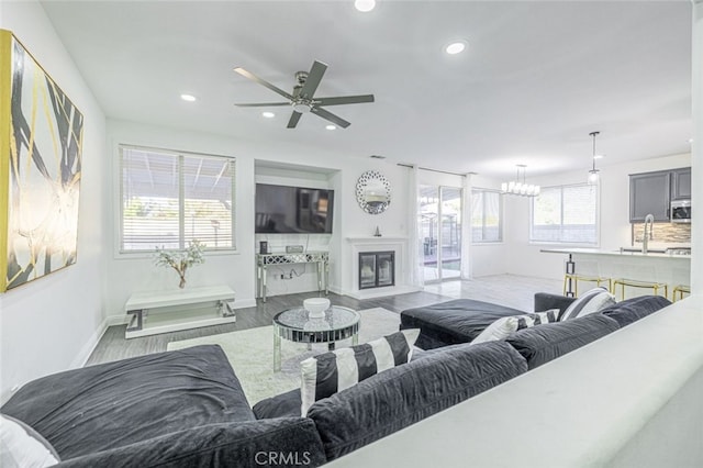 living room featuring light wood-type flooring, plenty of natural light, and ceiling fan