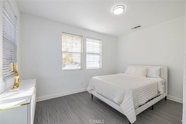 bedroom with dark hardwood / wood-style floors