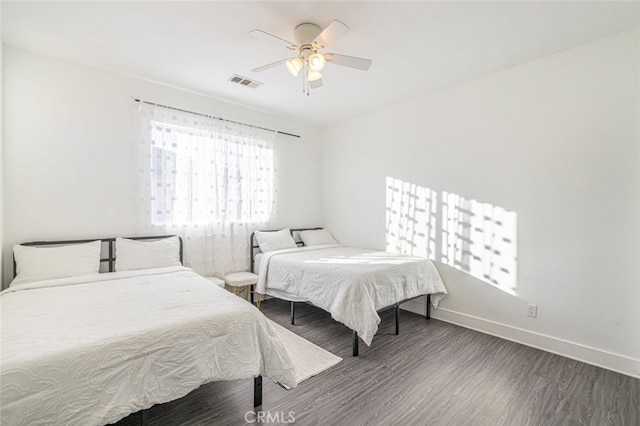 bedroom with dark hardwood / wood-style floors and ceiling fan