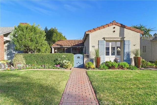 mediterranean / spanish house featuring a front lawn