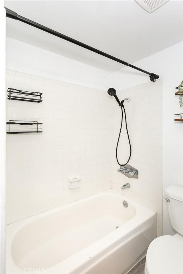 bathroom with tiled shower / bath and toilet