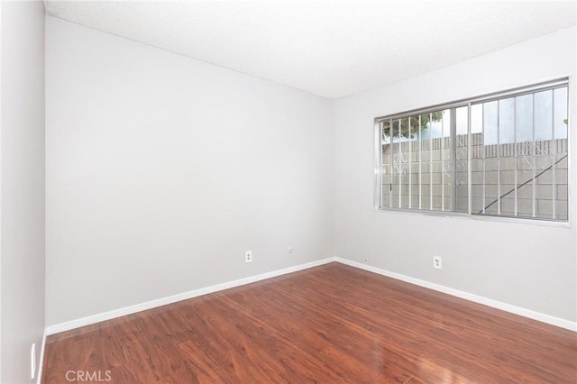 spare room featuring wood-type flooring