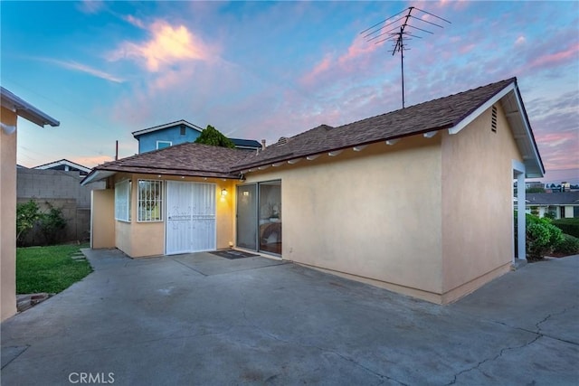 back house at dusk with a patio area