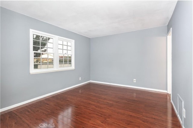 empty room with dark hardwood / wood-style flooring