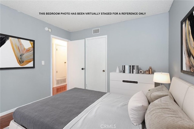 bedroom featuring wood-type flooring and a textured ceiling