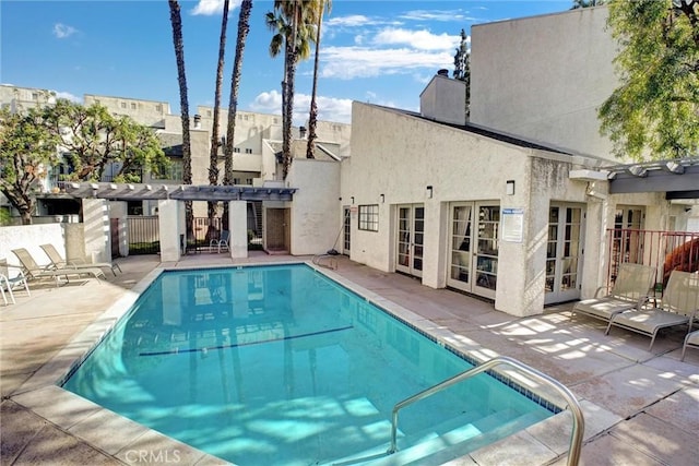 view of swimming pool with a pergola, a patio, and french doors