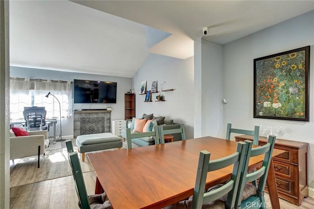 dining area featuring light wood-type flooring and lofted ceiling