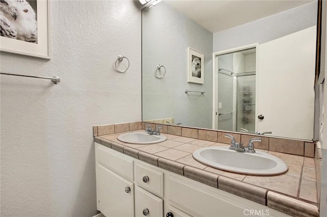 bathroom featuring vanity and a shower with door