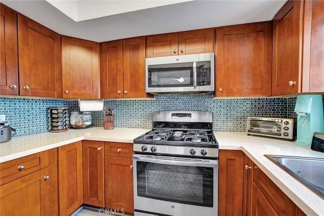 kitchen with decorative backsplash, sink, and appliances with stainless steel finishes