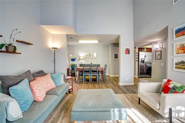 living room with a high ceiling and light hardwood / wood-style flooring