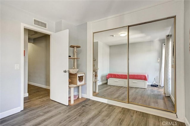 unfurnished bedroom with a closet and hardwood / wood-style flooring