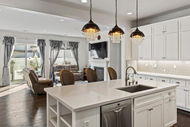 kitchen with white cabinetry, an island with sink, tasteful backsplash, stainless steel dishwasher, and sink