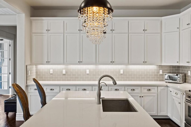 kitchen featuring sink, white cabinetry, and tasteful backsplash