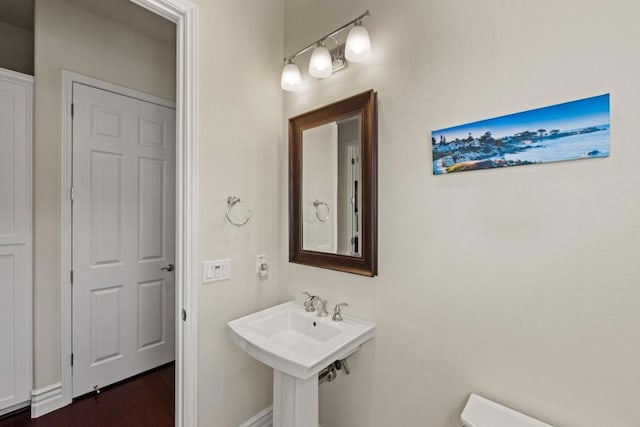 bathroom featuring sink, wood-type flooring, and toilet