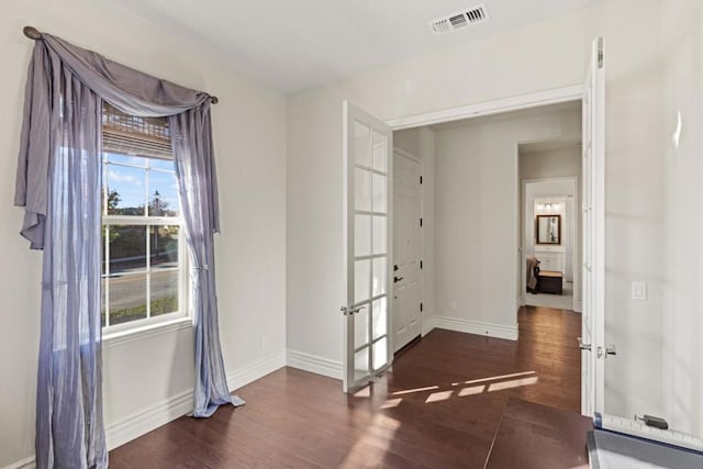 unfurnished room with a healthy amount of sunlight, french doors, and dark hardwood / wood-style floors