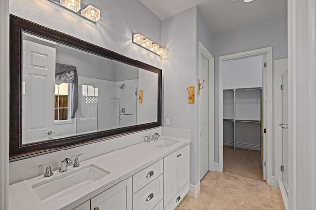 bathroom with a shower, tile patterned floors, and vanity