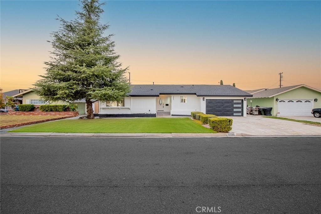 ranch-style home featuring a yard and a garage