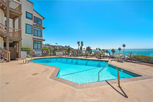 view of pool with a patio area and a water view