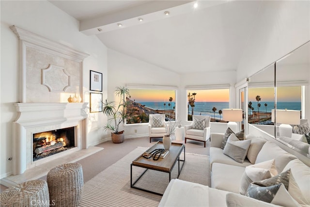 living room featuring high vaulted ceiling, a fireplace, beamed ceiling, a water view, and light carpet