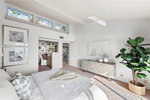 carpeted bedroom with vaulted ceiling with beams