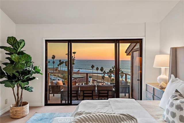 carpeted bedroom with multiple windows, access to exterior, and a water view