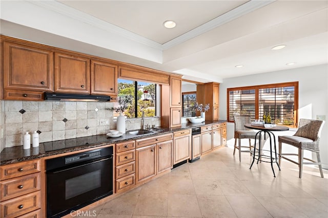 kitchen featuring sink, backsplash, dark stone counters, black appliances, and crown molding