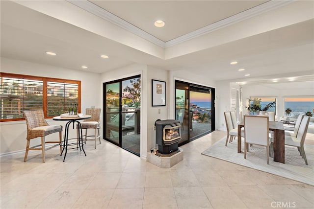 tiled dining area featuring ornamental molding and a wood stove