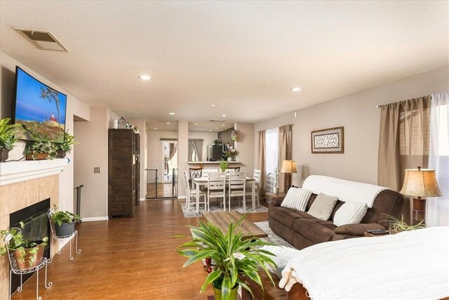 living room featuring hardwood / wood-style floors and a tiled fireplace