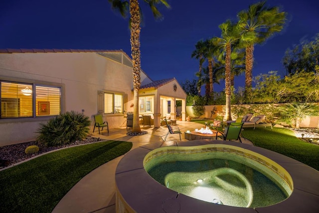 pool at night with a patio and an outdoor fire pit