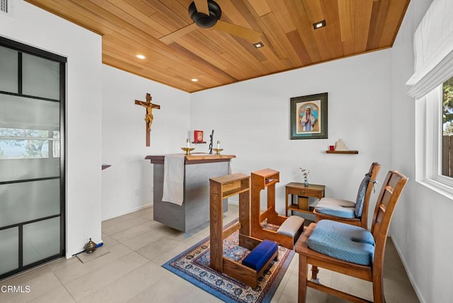 living area featuring ceiling fan and wooden ceiling