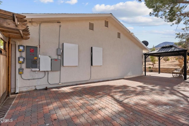 view of property exterior with a gazebo and a patio area