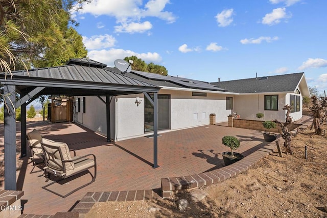 12724 Pallet Mesa Rd, Pearblossom, CA 93553 - rear view of property featuring a gazebo, a patio area, solar panels, and stucco siding