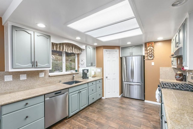 kitchen with tasteful backsplash, sink, dark wood-type flooring, and appliances with stainless steel finishes