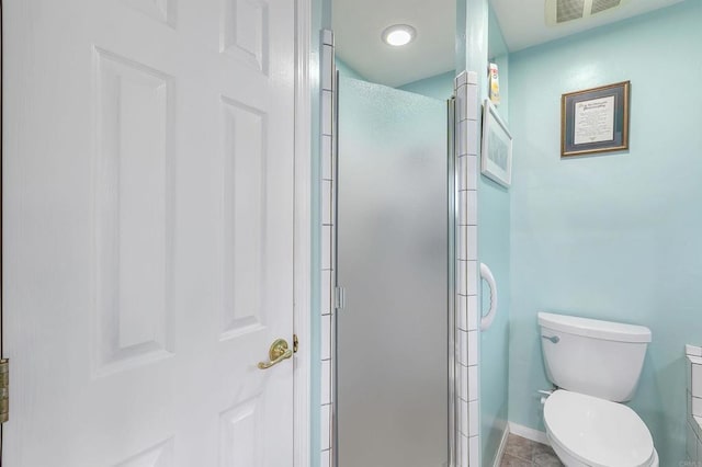 bathroom featuring tile patterned floors, toilet, and walk in shower