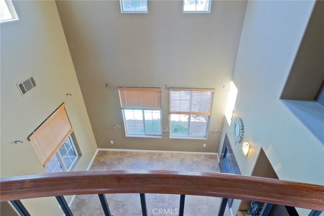 interior space featuring a towering ceiling and a healthy amount of sunlight