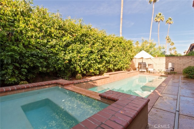 view of pool featuring an in ground hot tub