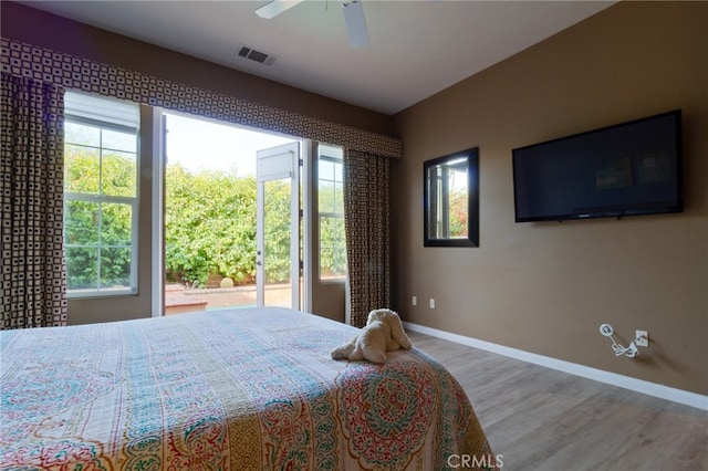 bedroom with multiple windows, hardwood / wood-style flooring, and ceiling fan