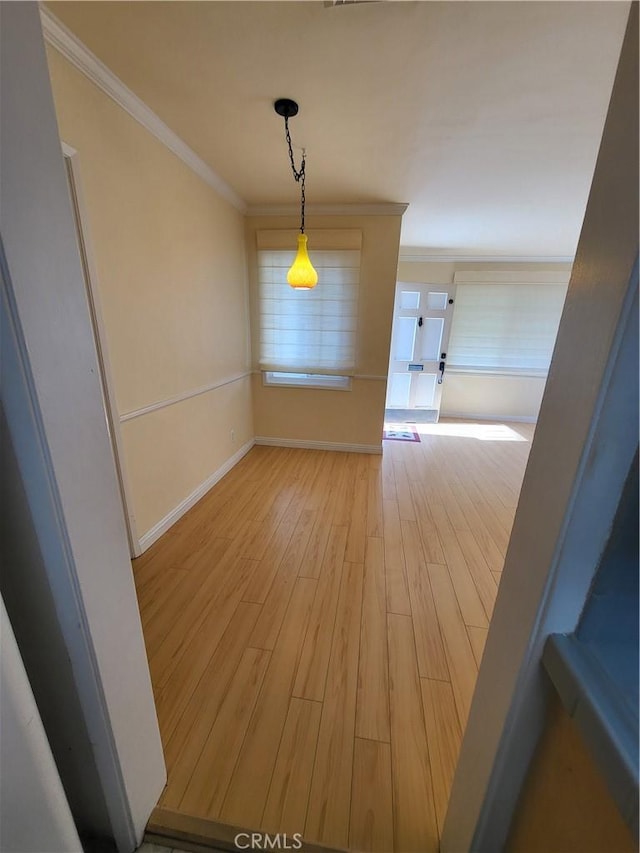 unfurnished dining area with crown molding and light hardwood / wood-style flooring