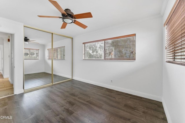 unfurnished bedroom featuring ceiling fan, a closet, dark hardwood / wood-style floors, and ornamental molding