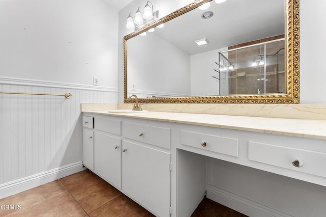 bathroom with tile patterned floors, vanity, and a shower with door