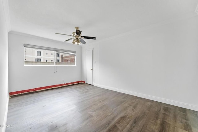 empty room with dark hardwood / wood-style flooring, ceiling fan, and ornamental molding