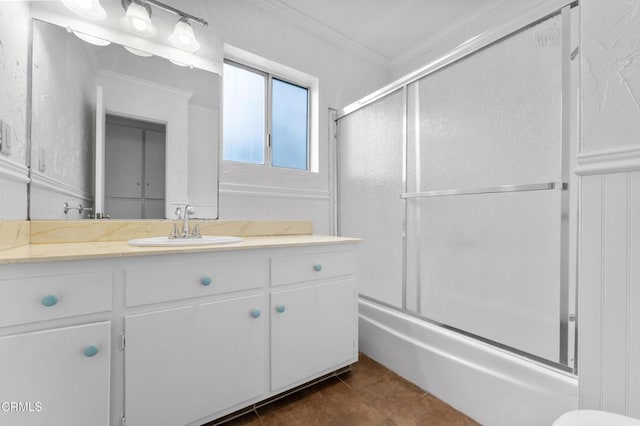 bathroom with combined bath / shower with glass door, vanity, tile patterned floors, and crown molding