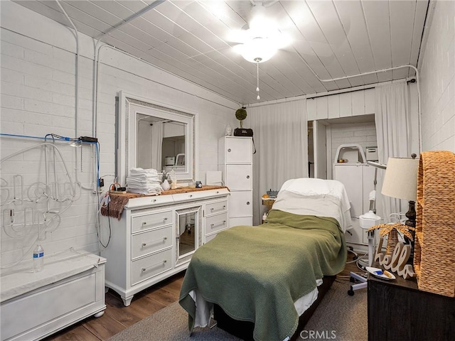 bedroom with wooden walls and dark wood-type flooring