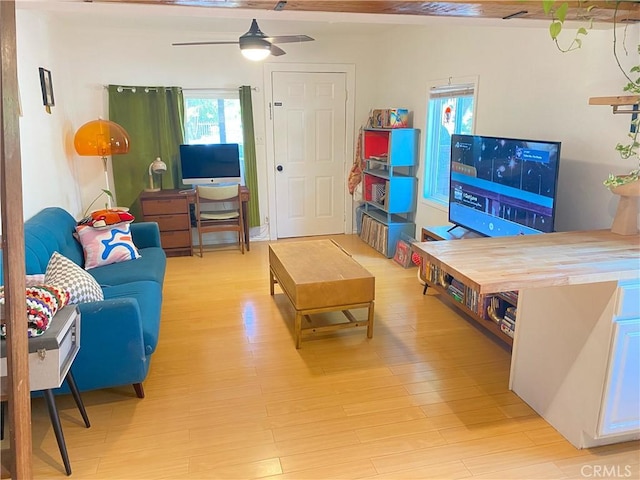 living room featuring light hardwood / wood-style flooring and ceiling fan